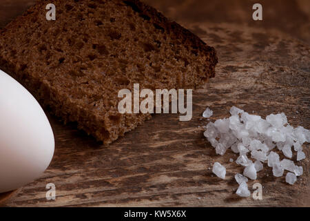 Pezzo di grossolana del pane di segale con il sale e le uova cibo tradizionale della gente comune in tempi antichi Foto Stock