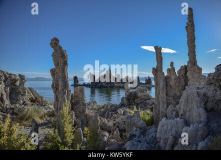 Più tufas, Mono lago, un cielo blu chiaro con una interessante cloud, e le montagne lontane, Mono Lago di tufo Riserva Naturale Statale, in California Foto Stock