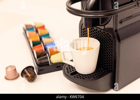 Macchina per il caffè espresso si prepara il caffè espresso, design moderno, capsule intorno, vista ravvicinata, dettagli. Foto Stock