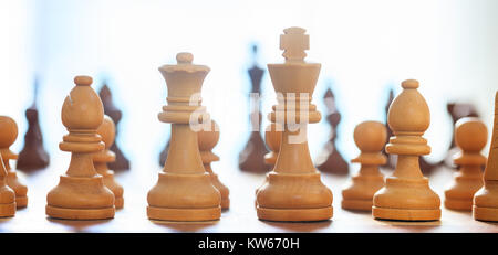 Pezzi di scacchi marrone chiaro. Vista ravvicinata del re, regina, vescovi, pegni con maggiori dettagli la sfocatura sullo sfondo. Foto Stock