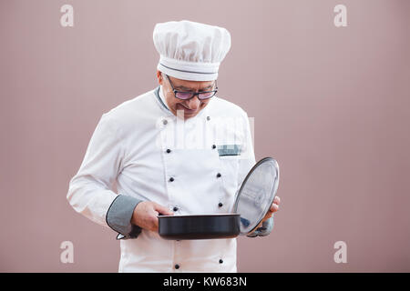 Ritratto del ristorante la chef in lavoro degustazione uniforme il pasto Foto Stock