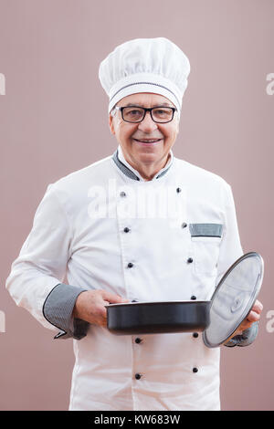 Ritratto del ristorante la chef in lavoro degustazione uniforme il pasto Foto Stock