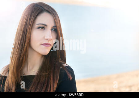 Ritratto di una donna, closeup, vista di profilo, pensando, pensieroso, greco, all'aperto in spiaggia, l'inverno. Foto Stock