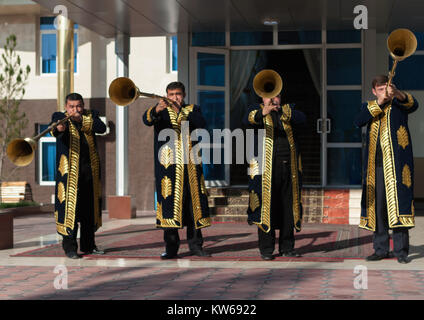 TASHKENT, UZBEKISTAN - 9 Dicembre 2011: musicista uomini in tradizionale kaftans giocando il karnay all'ingresso Foto Stock