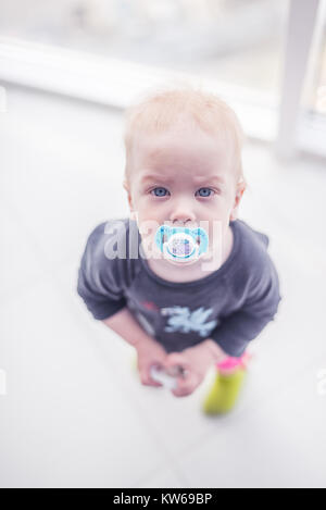 Carino bambino con succhietto con uno sfondo bianco Foto Stock