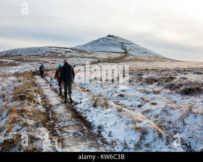 Persone che camminano verso Shutlingsloe hill nella neve il terzo punto più alto nel Cheshire a 506 metri dall'approccio attraverso la foresta a Macclesfield Foto Stock