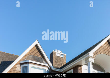 La parte superiore di una casa contro un cielo blu brillante Foto Stock