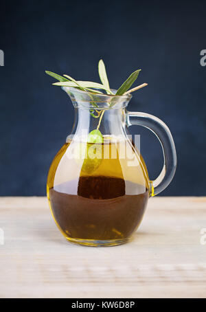 Oliva frutta in un barattolo di vetro di Olio di Oliva biologico sul tavolo di legno e sfondo Blackboard Foto Stock