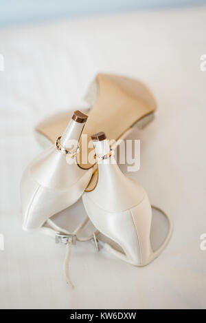 Bianco scarpe matrimonio con anelli d oro su di esso Foto Stock