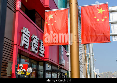KFC di Nanchang - rosso brillante nazionale cinese bandiere della parte anteriore di un KFC (Kentucky Fried Chicken) store presso il centro cittadino di Nanchang, Jiangxi, Cina. Foto Stock