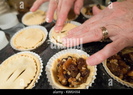 Fare pasticci di carne macinata: onorevoli mani posto cerchi sulla ontop pastoso di torte salate con ripieno di carne macinata per completare la realizzazione delle torte di carne macinata. 14 di 16 Foto Stock