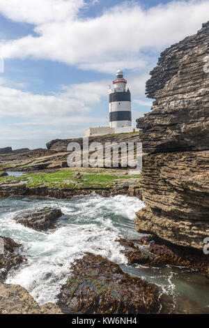 Hook Head Lighthouse vista dal rocky foreshore Foto Stock