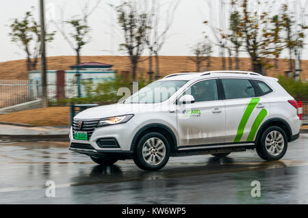 Spostando il colpo di SAIC Roewe eRX5 EV400 batteria auto elettrica essendo pilotati a Pudong come offerto in car sharing scheme EVcard. Foto Stock