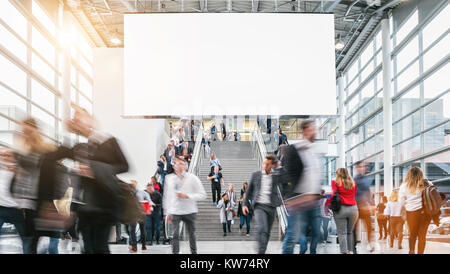 Folla di offuscata la gente di affari ad una fiera commerciale piano Foto Stock