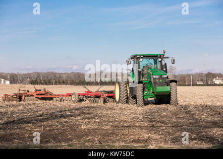 Verde di grandi dimensioni trattore John Deere seduto in un campo di mais in East Hampton, NY Foto Stock