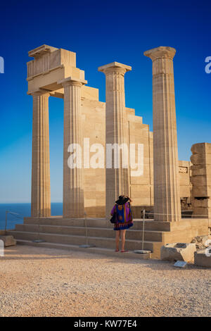 Donna hat nella parte anteriore del tempio dorico di Athena Lindia sulla Acropoli di Lindos (Rhodes, Grecia) Foto Stock