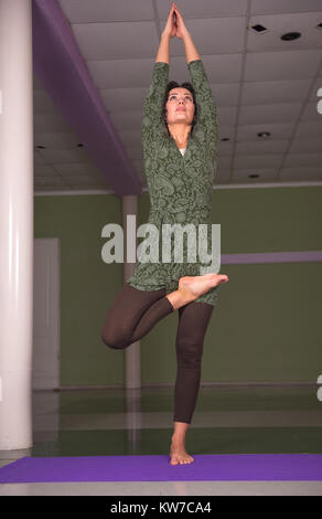 Lo Yoga trainer insegna lezione di yoga in palestra Foto Stock