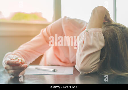 Grande concetto del divorzio, fine del rapporto, triste giovane donna, firma un accordo di divorzio, con le mani in faccia. Foto Stock