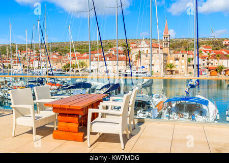 Porto di Milna, Croazia - Sep 12, 2017: tavolo con sedie a sdraio sulla terrazza ristorante affacciato sul porto di Milna con barche a vela, isola di Brac, Croazia. Foto Stock