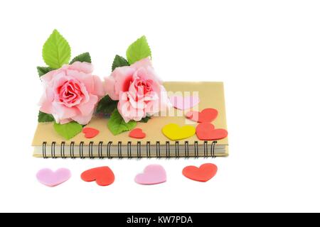 Cuore con rose rosa sul libro su sfondo bianco il giorno di san valentino concetto Foto Stock