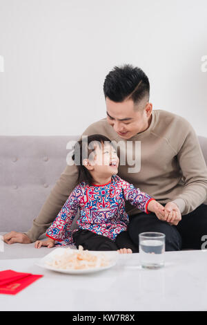 Il vietnamita padre e figlia festeggiare il nuovo anno a casa. Tet Holiday. Foto Stock