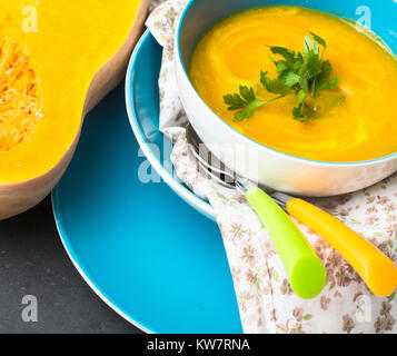 Zuppa di zucca e una metà hokkaido su legno, fuoco selettivo Foto Stock