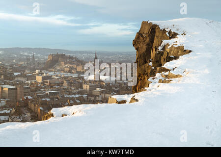 Una vista sul Castello di Edimburgo e degli edifici circostanti da Salisbury Crags dopo una nevicata di giorno Foto Stock