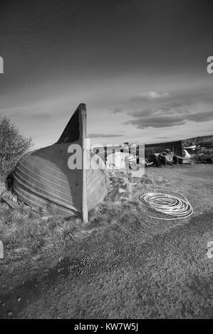 Vecchio Aringa capovolta Barche usate come magazzini di pescatori sull'isola di Lindisfarne sulla costa Northumbrian, UK,GB, Inghilterra. Foto Stock