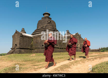 I monaci buddisti raccolgono mattina alms nella parte anteriore del Laymyetnha (Lemyethna) tempio di Mrauk U, Birmania (Myanmar) Foto Stock