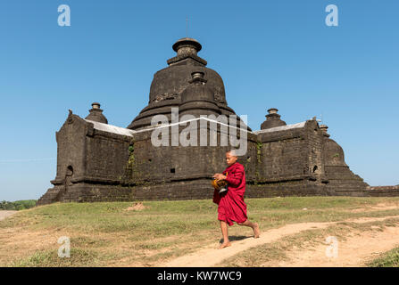 Il debuttante monaco buddista raccoglie mattina alms nella parte anteriore del Laymyetnha (Lemyethna) tempio di Mrauk U, Birmania (Myanmar) Foto Stock