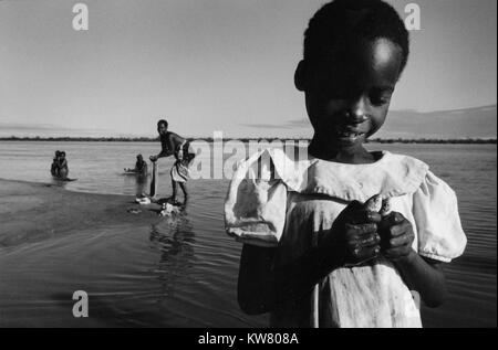 Inondazioni in Mozambico marzo 2000; una giovane ragazza detiene due piccoli pesci catturati da sua madre utilizzando un pezzo di stoffa come un net. Mombane Foto Stock