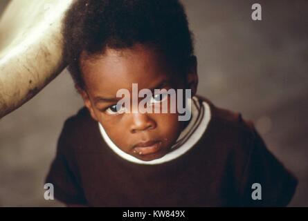 Un bambino nero sul retro portico di una casa in una molto bassa area di reddito su Chicago lato ovest di Chicago, Illinois, Giugno 1973. Immagine cortesia John White/US National Archives. Immagine cortesia archivi nazionali. Foto Stock