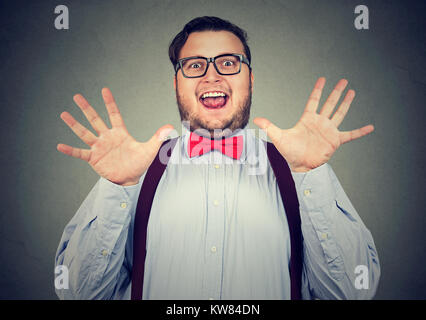 Giovane uomo obesi cercando super eccitati in posa in telecamera avente una grande notizia. Foto Stock