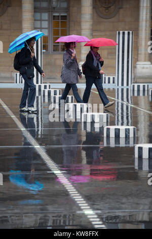 Francia, Parigi (75), ombrelloni a piedi attraverso le colonne di Daniel Buren, artista concettuale. Foto Stock