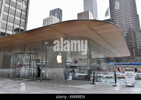 Chicago, Stati Uniti d'America. Il 31 dicembre 2017. Segnali di avvertimento i passanti di caduta di ghiaccio sono sul display intorno alla nuova ammiraglia Apple Store di North Michigan Avenue, vicino al fiume Chicago. L'edificio, progettato da architetti britannici Foster + Partner, ha un tetto di forma simile a quella del coperchio di un computer portatile Apple e sembra mancare visibile grondaie. Ghiaccioli che si sono formate nella corrente a temperature sotto lo zero sono caduto a terra al di sotto di pericolo per il pubblico e il negozio è attualmente rivolto critiche dai locali di sviluppare una soluzione. Credito: Stephen Chung / Alamy Live News Foto Stock