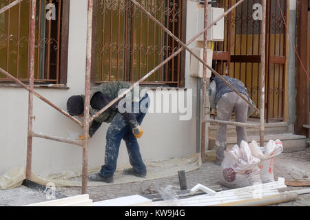 Dicembre 2017 - uomini al lavoro sulle pareti esterne di ripristinare una vecchia casa nella parte vecchia della città di Eskisehir, Turchia Foto Stock