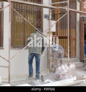 Dicembre 2017 - uomini al lavoro sulle pareti esterne di ripristinare una vecchia casa nella parte vecchia della città di Eskisehir, Turchia Foto Stock