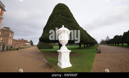 Statua di pietra coperta in inverno in plastica copertura protettiva che mostra topiaria da albero a Hampton Court Palace Foto Stock