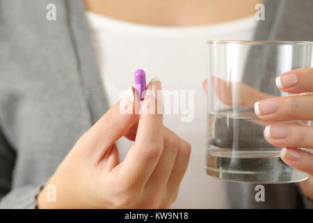 In prossimità di una donna mani tenendo una pillola e un bicchiere di acqua Foto Stock