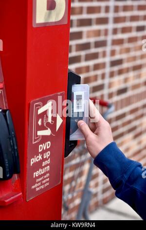 Persona di restituire un filmato Redbox presso un chiosco Redbox Foto Stock