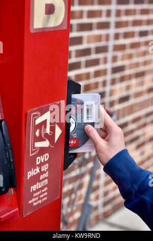 Persona di restituire un filmato Redbox presso un chiosco Redbox Foto Stock