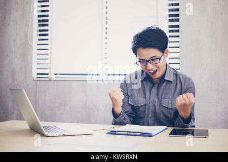 Gli imprenditori asiatici il successo e il concetto vincente - happy team con alzata fino a mani celebra la conquista e realizzazioni Foto Stock