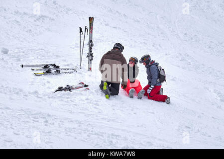 WINTERBERG, Germania - 16 febbraio 2017: Donna seduta su una pista da sci con la gamba ferita di essere preso cura di al carosello sciistico Winterberg Foto Stock