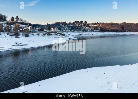 Sera vista sul lago Rursee al villaggio di Rurberg con la neve in inverno in Eifel, Germania. Foto Stock