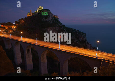 Esposizione nel tempo di Èze-Village con il suo ponte di accesso. Il nome del villaggio appare sulla scogliera con una proiezione laser. Costa Azzurra, Francia. Foto Stock