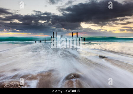 Il South Australia il famoso porto spiaggia Willunga Jetty rovine con le onde che si infrangono Foto Stock