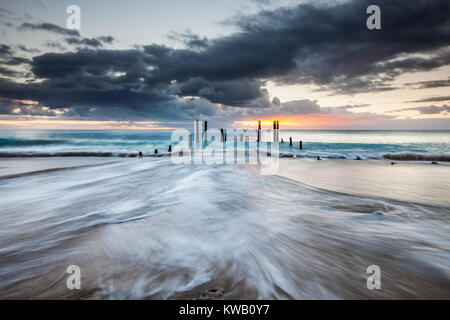 Il South Australia il famoso porto spiaggia Willunga Jetty rovine con le onde che si infrangono Foto Stock