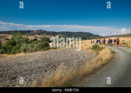 Casale Marittimo, Pisa, Italia - 12 Luglio 2017: gli escursionisti a piedi attraverso la campagna in estate piena di cipressi, balle di fieno e il cielo blu, panoramica Foto Stock