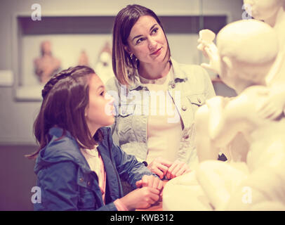 Positivo madre e figlia guardando statue classiche in museo Foto Stock