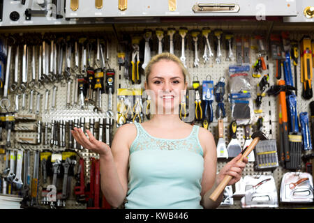 Ritratto di giovane donna felice presso la cassa di contenimento in martello attrezzo-ware shop Foto Stock